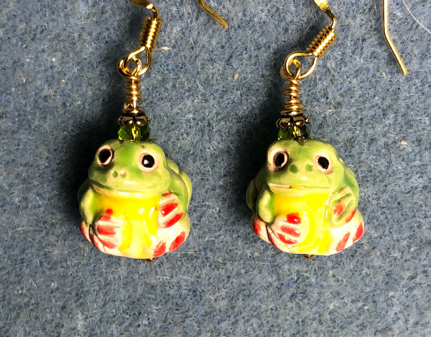 Small green, yellow, and red ceramic frog bead earrings adorned with olive green Chinese crystal beads.