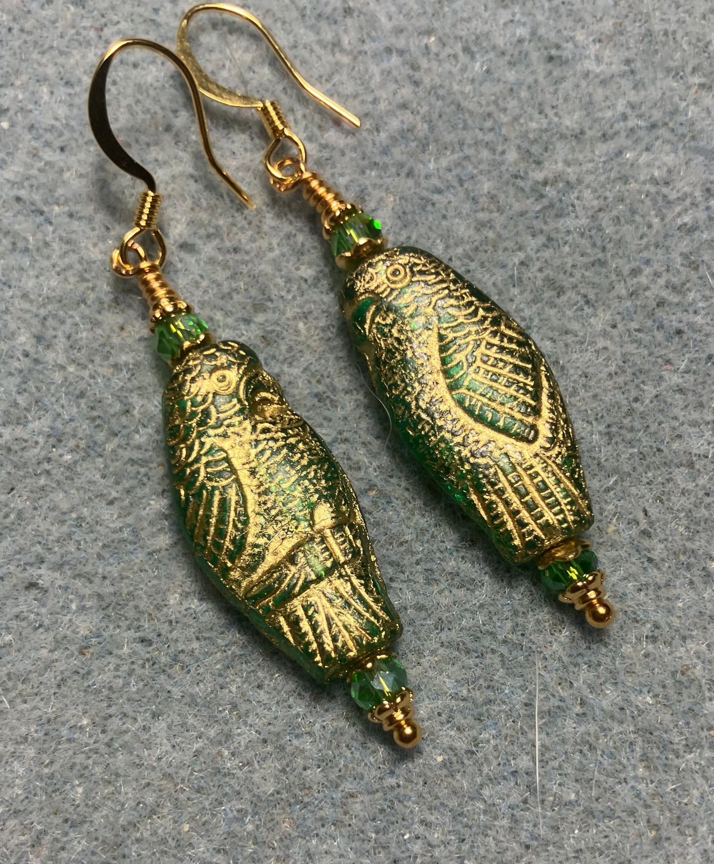 Large green teal (with gold wash) Czech glass parrot bead earrings adorned with green Chinese crystal beads.