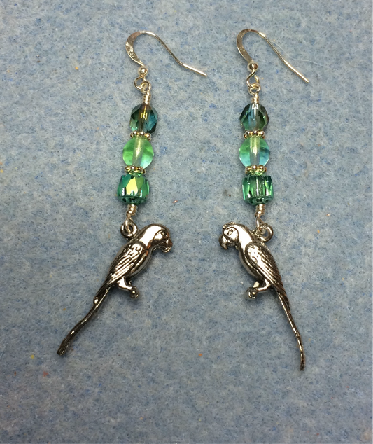 Silver parrot charm earrings adorned with light green Czech glass beads