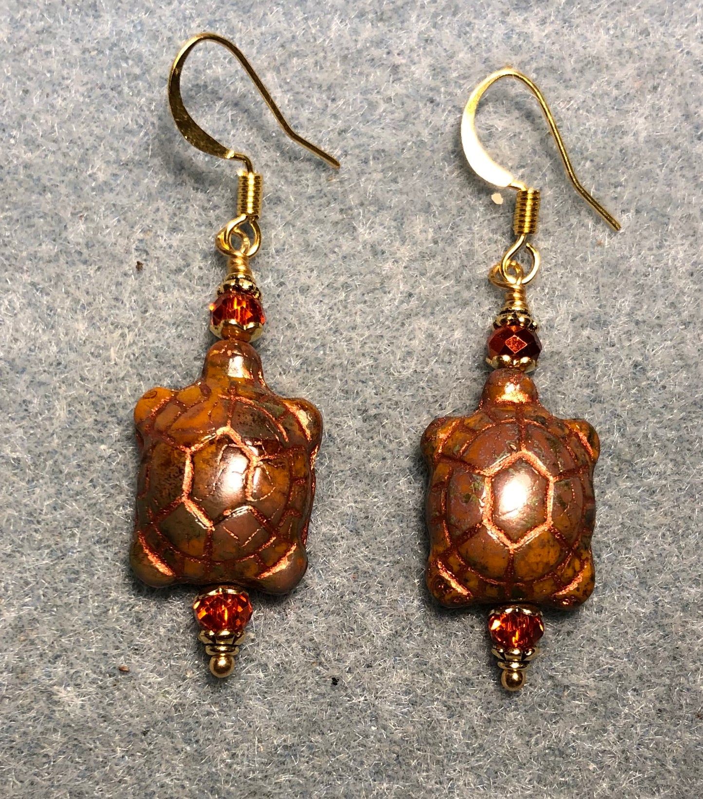 Orange brown Czech glass turtle bead earrings adorned with orange Chinese crystal beads.