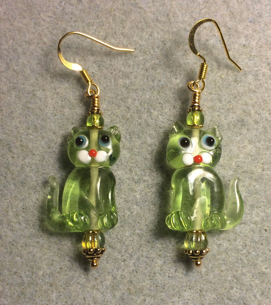 Translucent light olive green lamp work cat bead earrings adorned with olive green Czech glass beads.