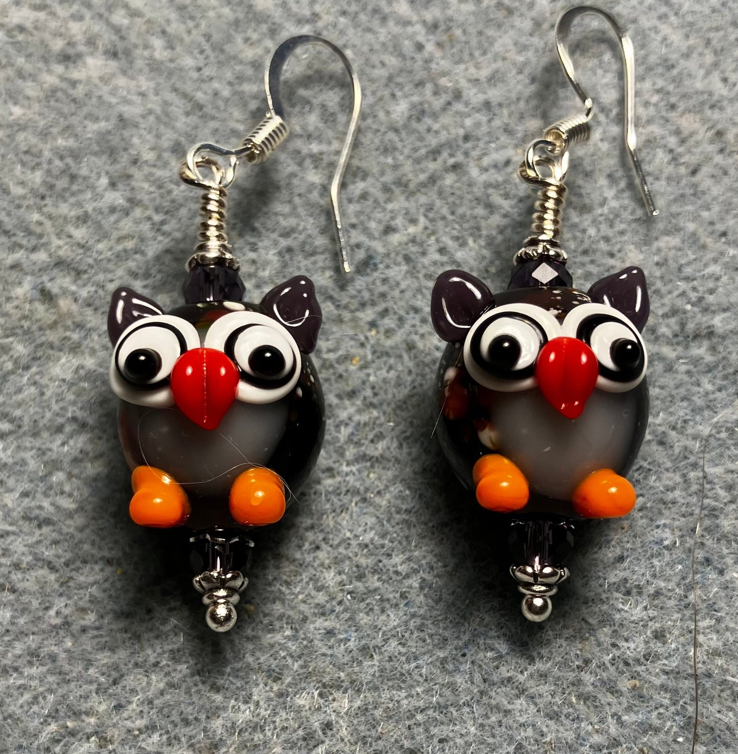 Purple, orange, and red lamp work owl bead earrings adorned with purple Chinese crystal beads.