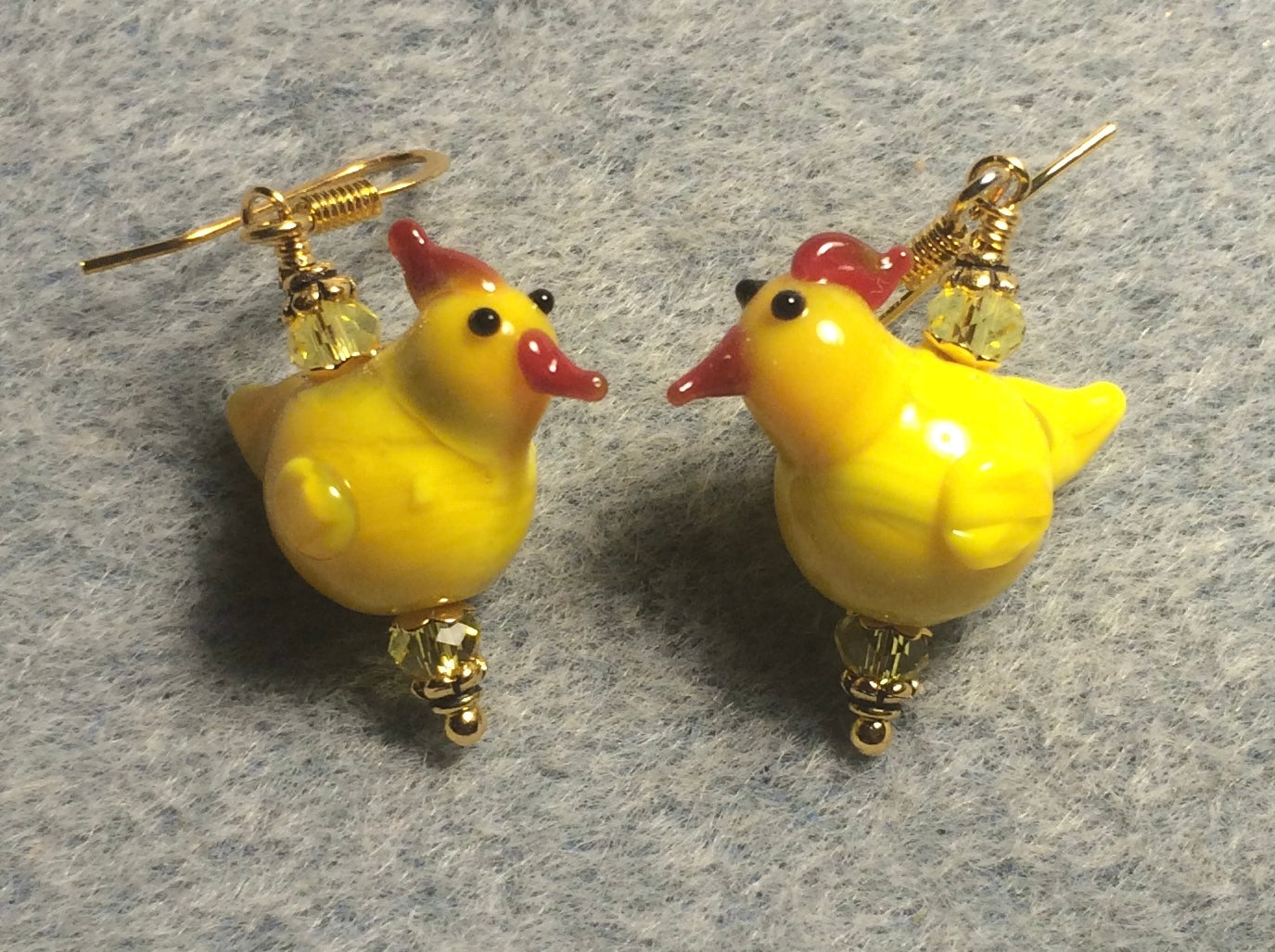 Small yellow lamp work chicken bead earrings adorned with yellow Chinese crystal beads.
