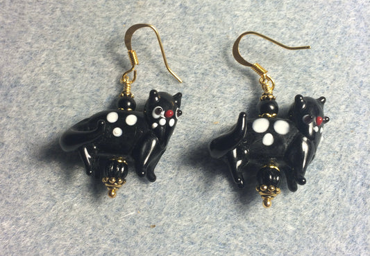 Opaque black lamp work spotted cat bead earrings adorned with black Czech glass beads.