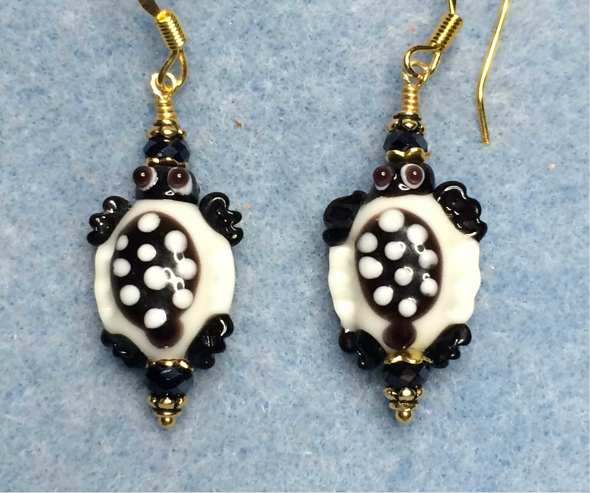 Black and white lamp work spotted turtle bead earrings adorned with black Chinese crystal beads.