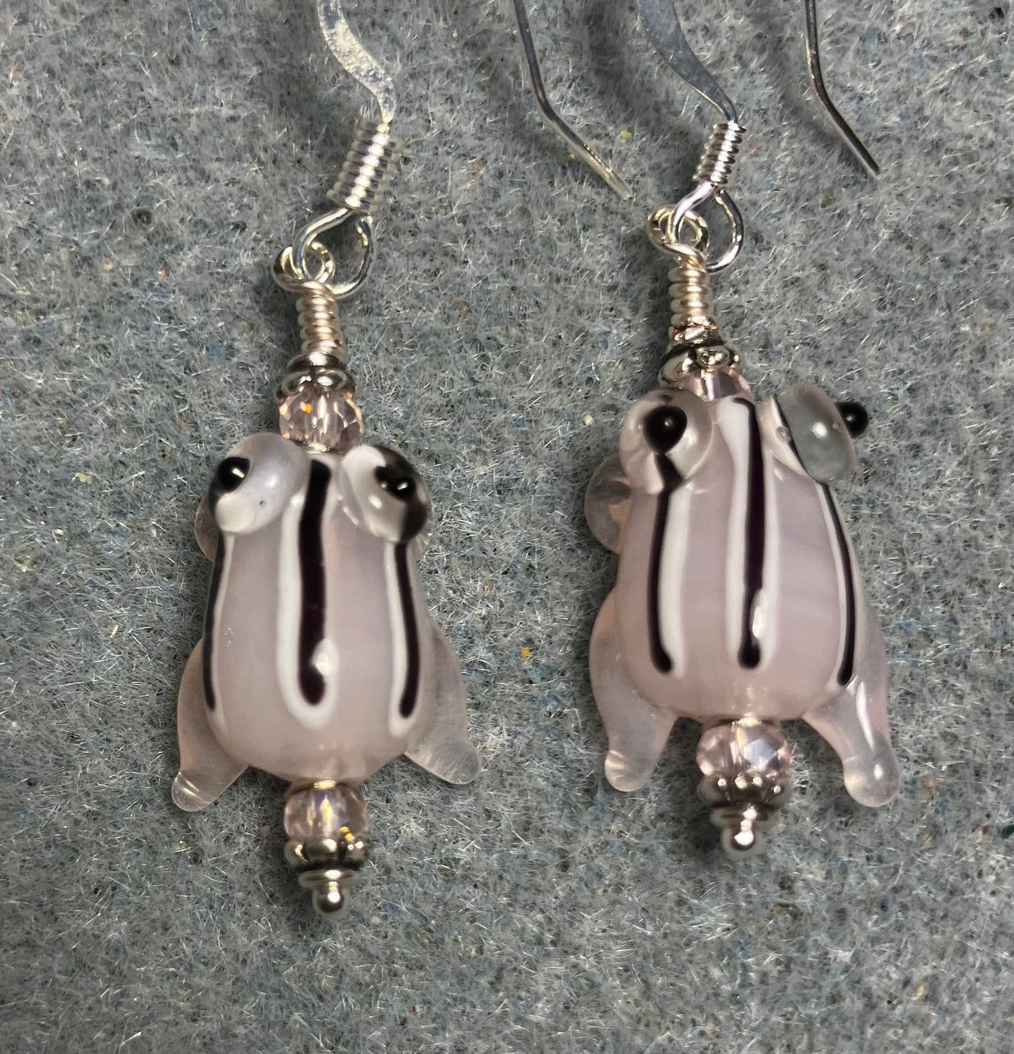 Very small translucent pink with black stripes lamp work frog bead earrings adorned with light pink Chinese crystal beads.
