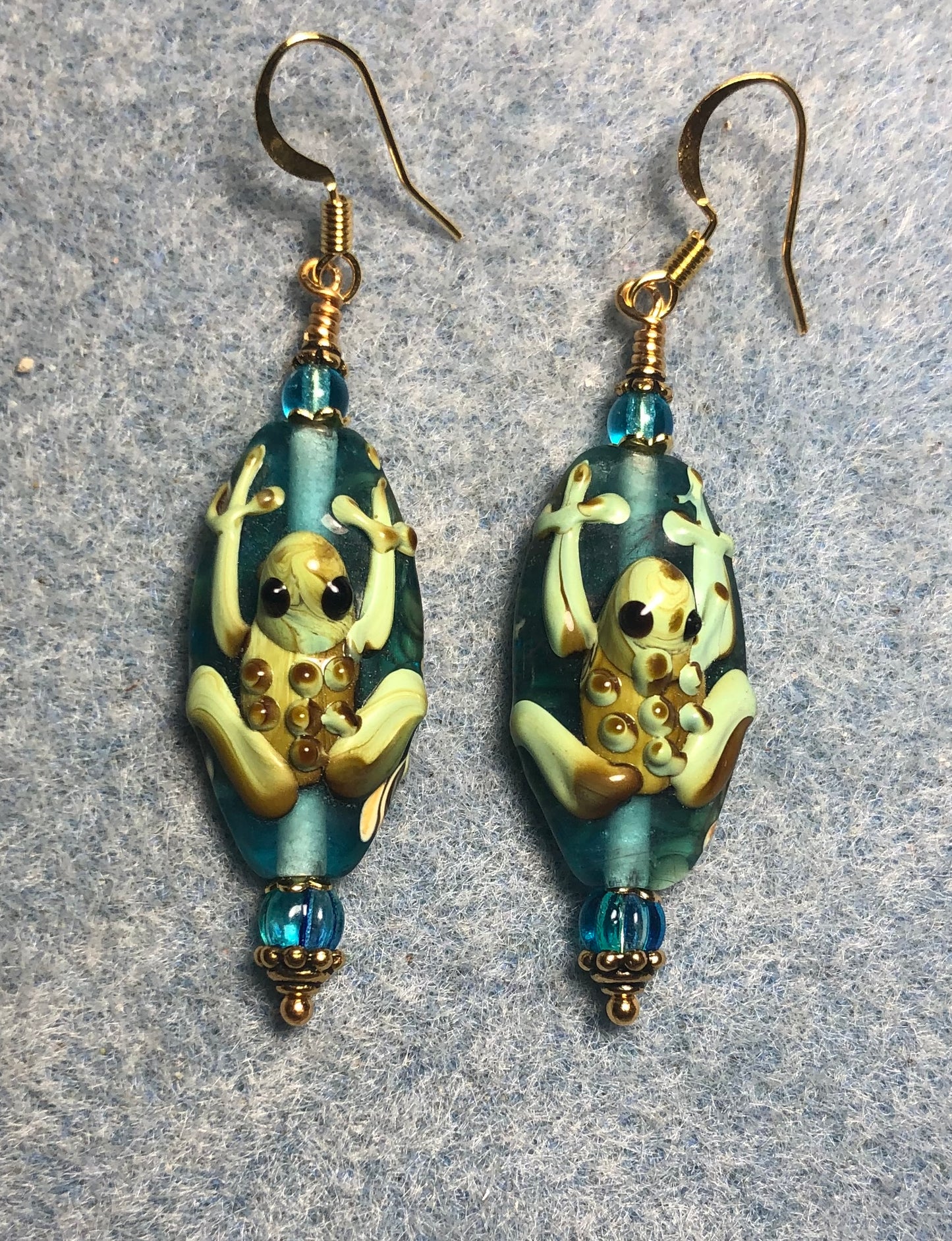 Turquoise and green lamp work frog bead earrings adorned with turquoise Czech glass beads.