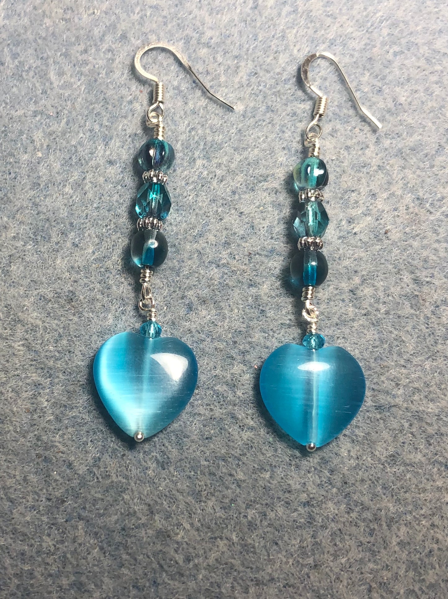 Turquoise fiber optic (cat’s eye) Czech glass heart bead earrings adorned with turquoise Czech glass beads.