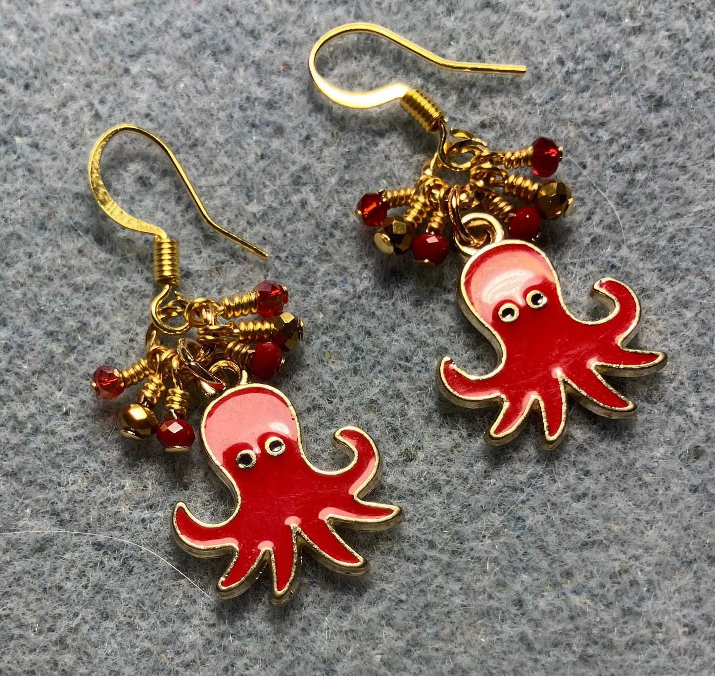 Red and gold enamel octopus charm earrings adorned with tiny dangling red and gold Chinese crystal beads.