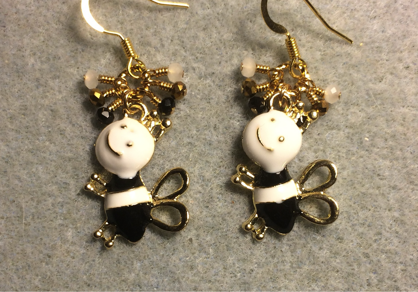 Black and white enamel silly honeybee charm earrings adorned with tiny dangling black, white, and gold Chinese crystal beads.