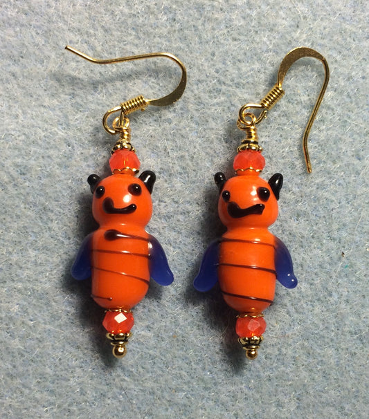 Orange and dark blue lamp work honeybee bead earrings adorned with orange Chinese crystal beads.