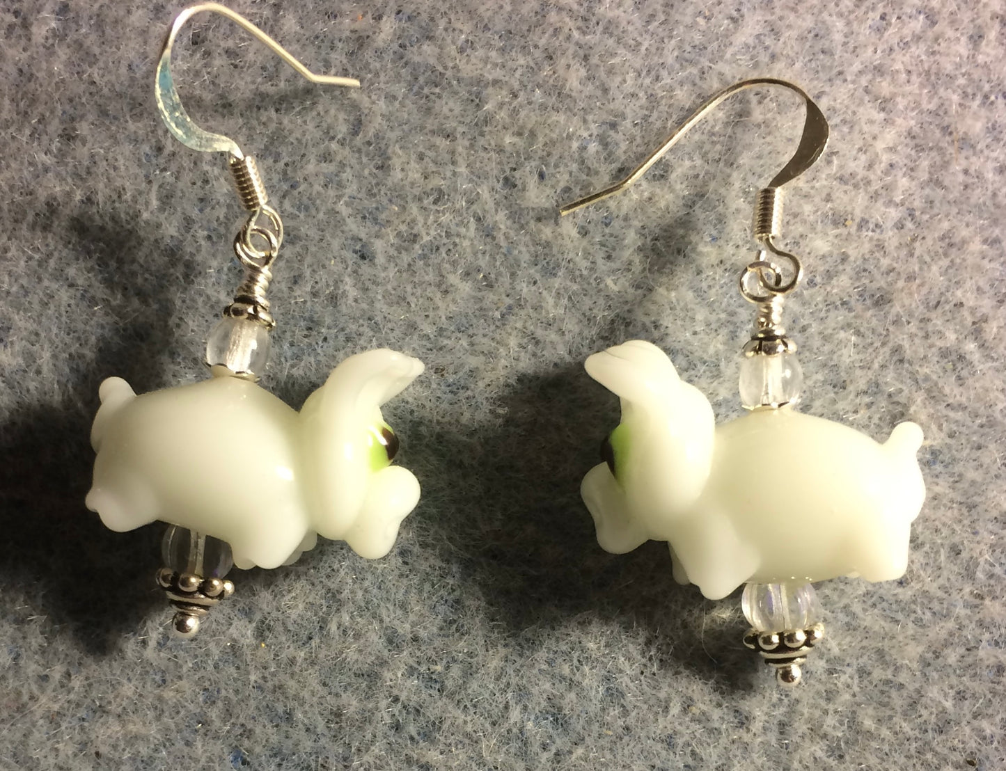 White lamp work pig bead earrings adorned with clear Czech glass beads.