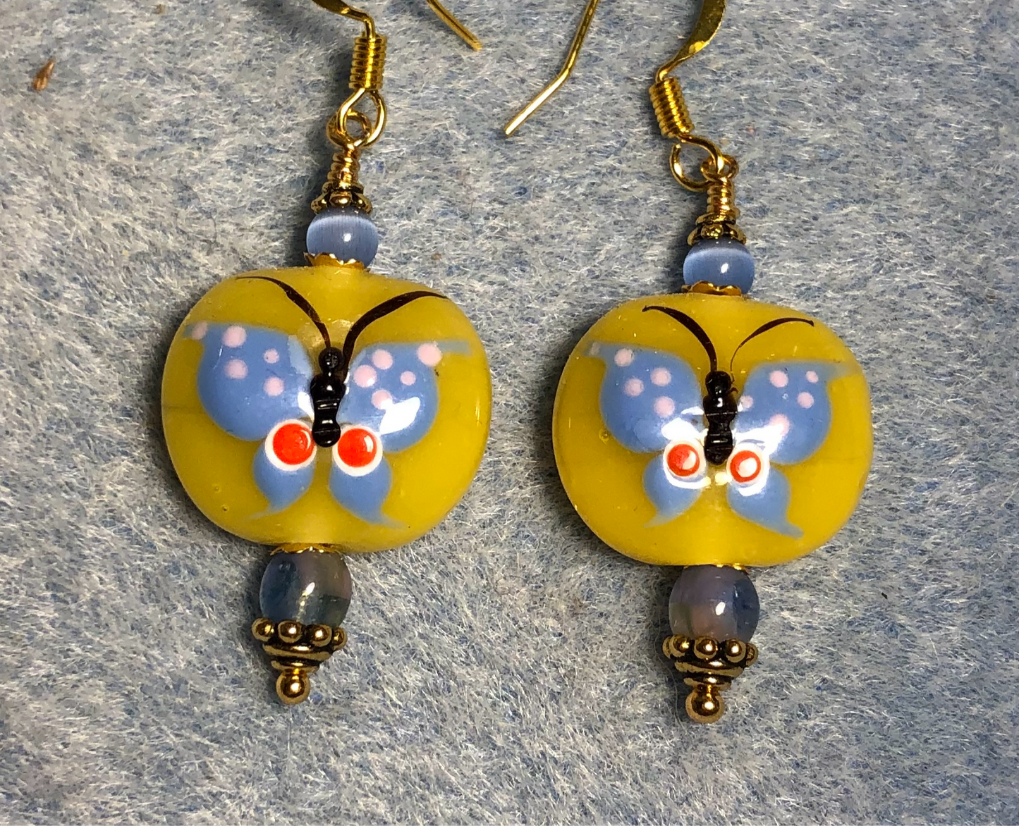 Yellow and light blue lamp work butterfly bead earrings adorned with light blue Czech glass beads.