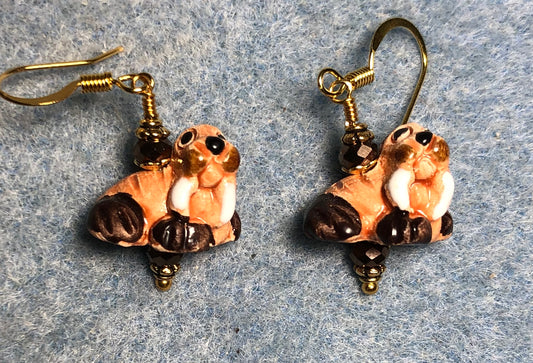 Small brown, tan and white ceramic walrus bead earrings adorned with brown Chinese crystal beads.