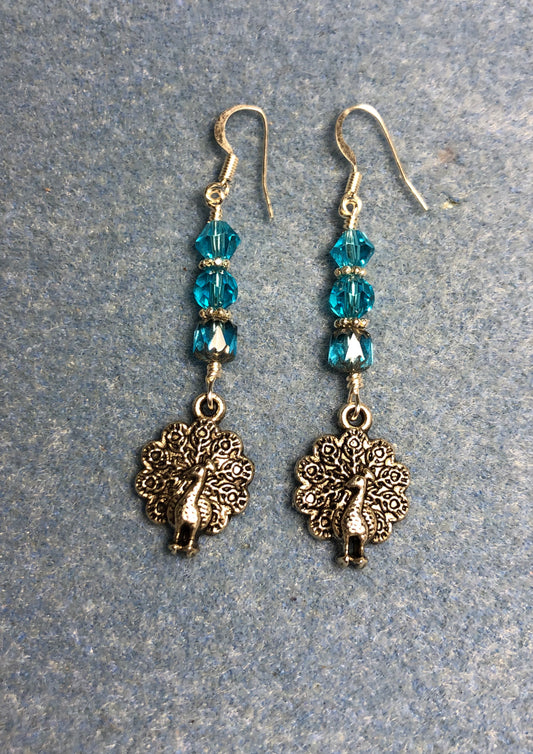 Silver peacock charm earrings adorned with turquoise Czech glass beads