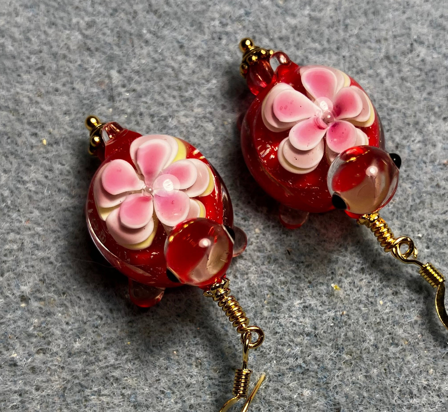 Large red and pink lamp work turtle bead earrings adorned with red Czech glass beads.