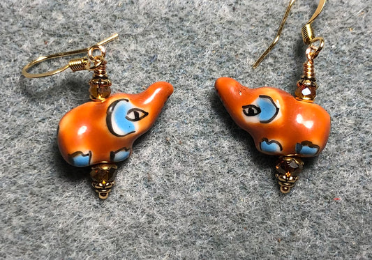 Small orange and light blue ceramic elephant bead earrings adorned with amber Chinese crystal beads.