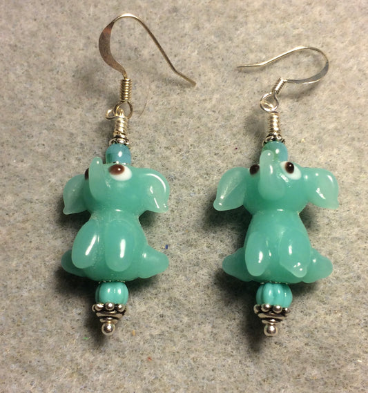 Opaque light turquoise lamp work sitting elephant bead earrings adorned with light turquoise Czech glass beads.
