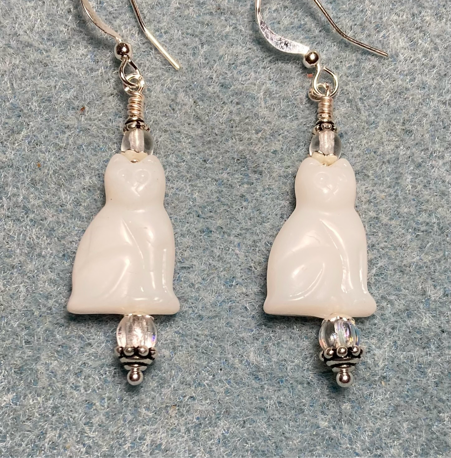 Shiny white Czech glass cat bead earrings adorned with clear Czech glass beads.