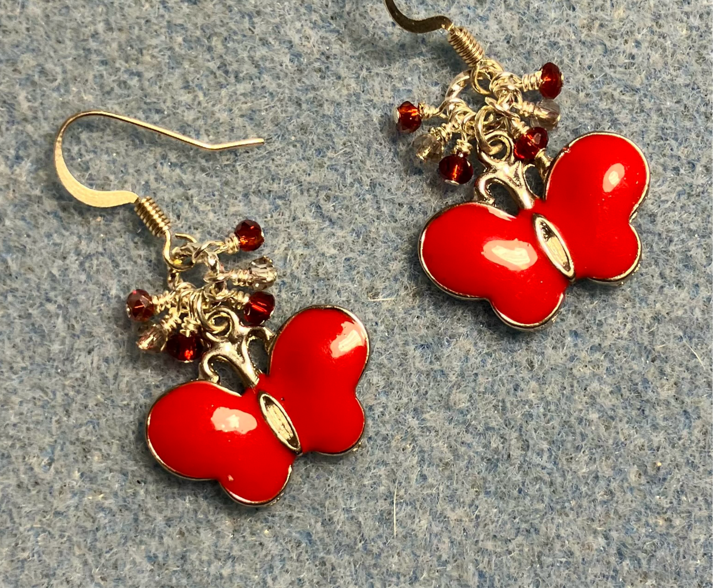 Red and silver enamel butterfly charm earrings adorned with tiny dangling red and clear Chinese crystal beads.