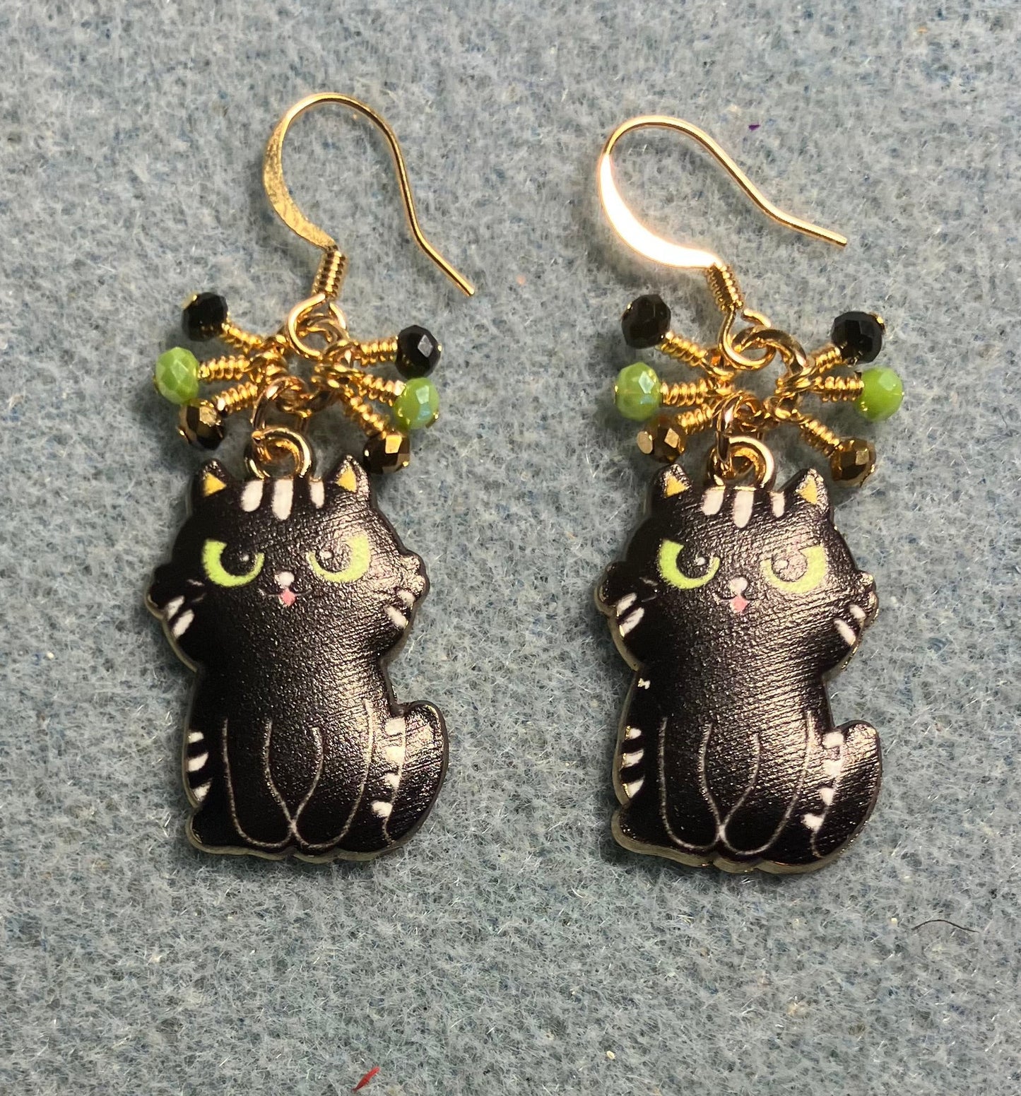 Black enamel cat charm earrings adorned with tiny dangling black, gold, and green Chinese crystal beads.