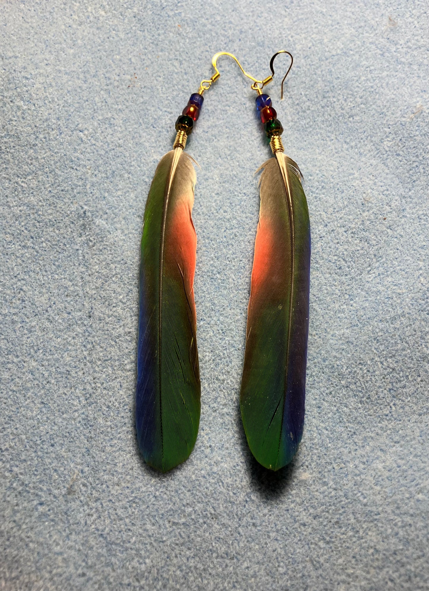 Green, red, and blue Pionus parrot feather earrings adorned with green, red, and blue Czech glass beads