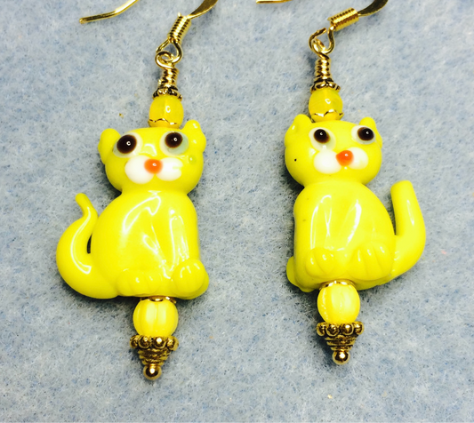 Opaque yellow lamp work cat bead earrings adorned with yellow Czech glass beads.