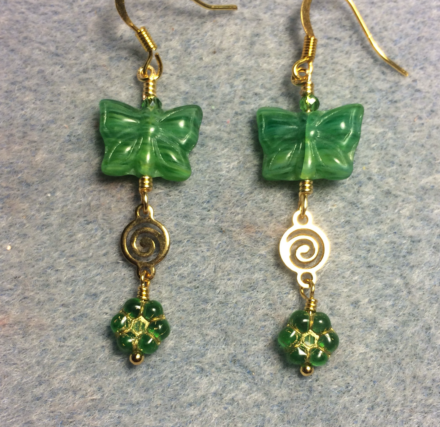 Bright green Czech glass butterfly bead earrings adorned with gold swirly connectors and bright green Czech glass daisy beads.