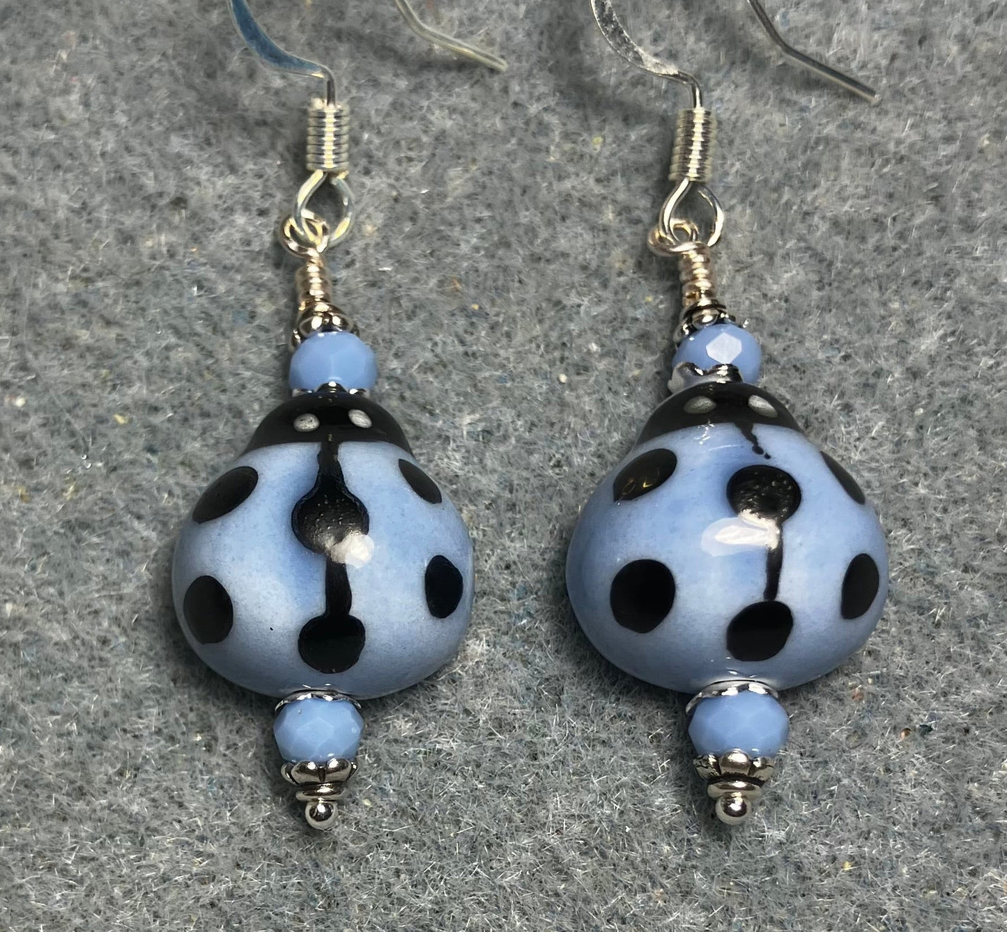Light blue and black ceramic ladybug bead earrings adorned with light blue Chinese crystal beads.