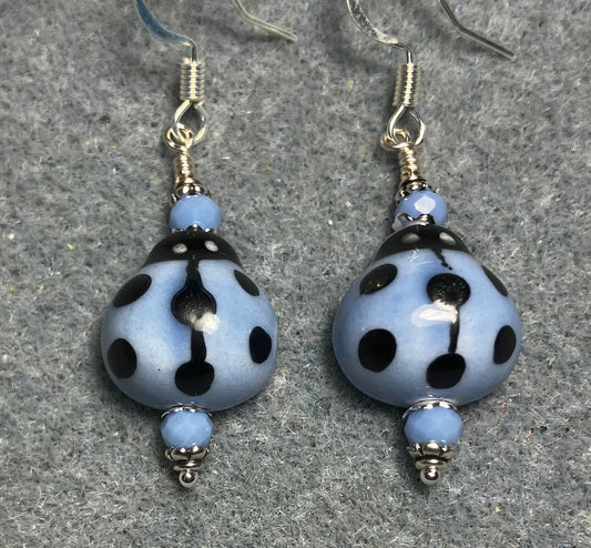 Light blue and black ceramic ladybug bead earrings adorned with light blue Chinese crystal beads.