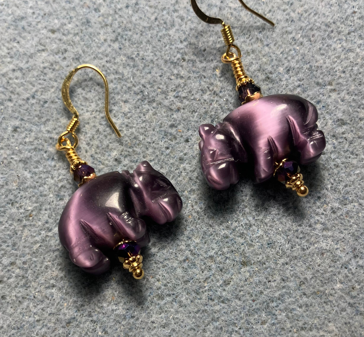 Purple fiber optic (cat’s eye)hippo bead earrings adorned with purple Chinese crystal beads.