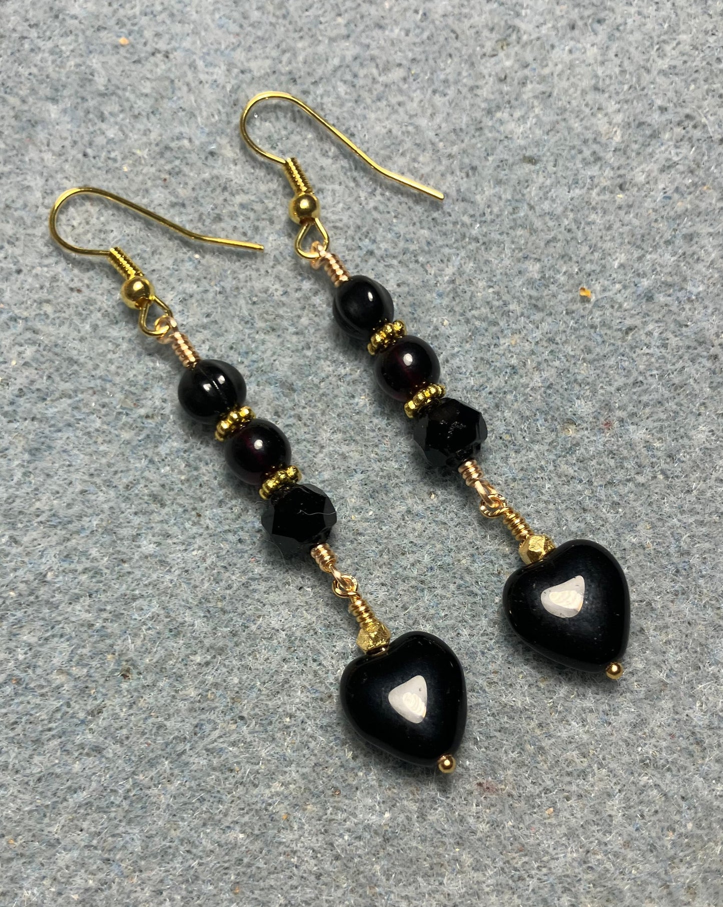 Small black Czech glass heart bead earrings adorned with black Czech glass beads.