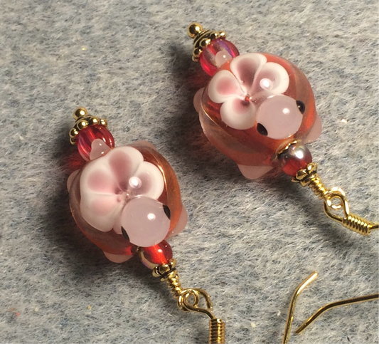 Red and pink lamp work turtle bead earrings adorned with red Czech glass beads.