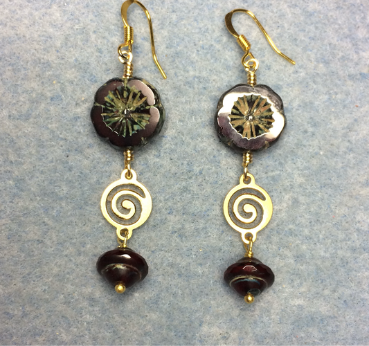 Dark red Czech glass pansy bead earrings adorned with gold swirly connectors and dark red Czech glass Saturn beads.