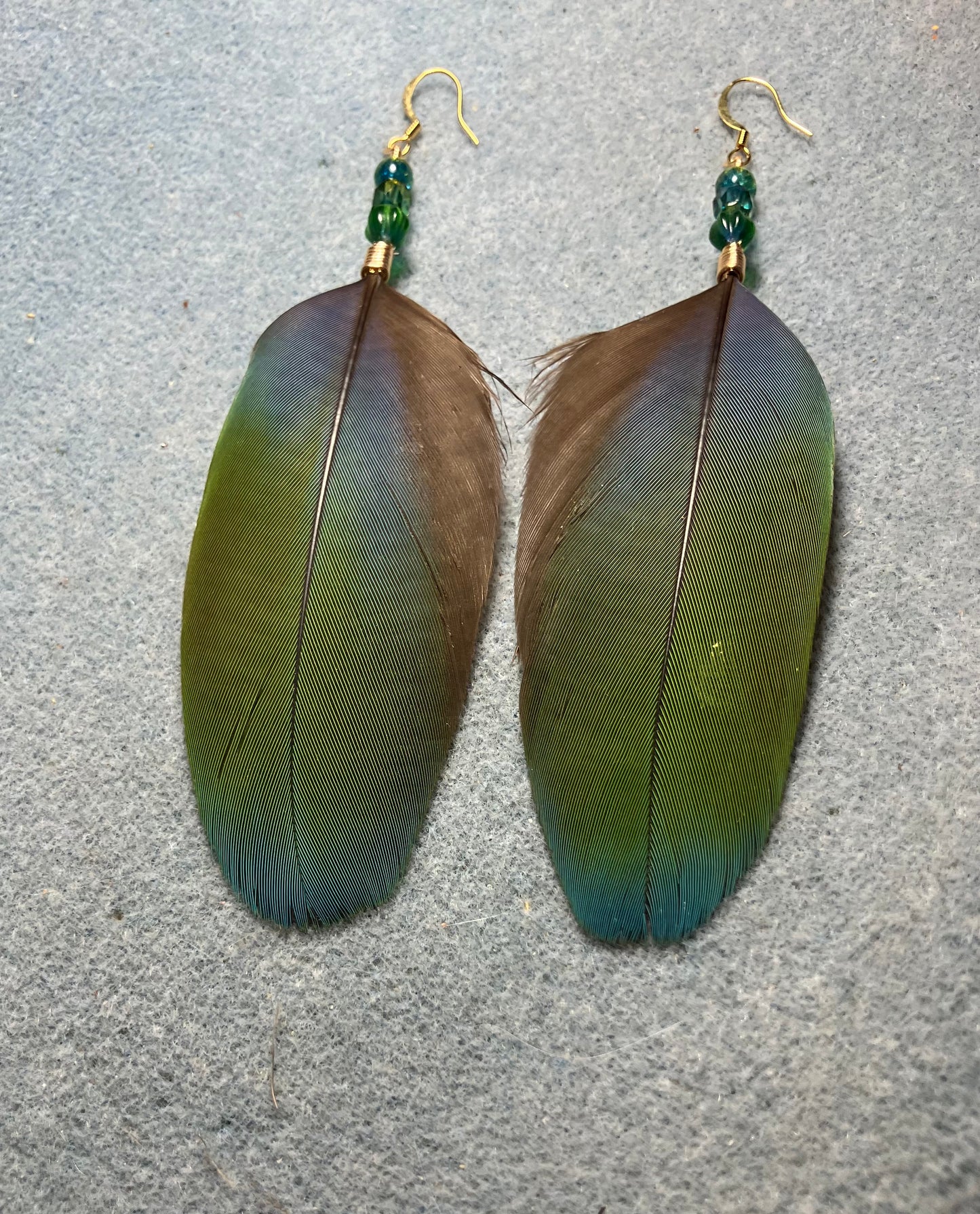 Blue and green scarlet macaw feather earrings adorned with blue green Czech glass beads.