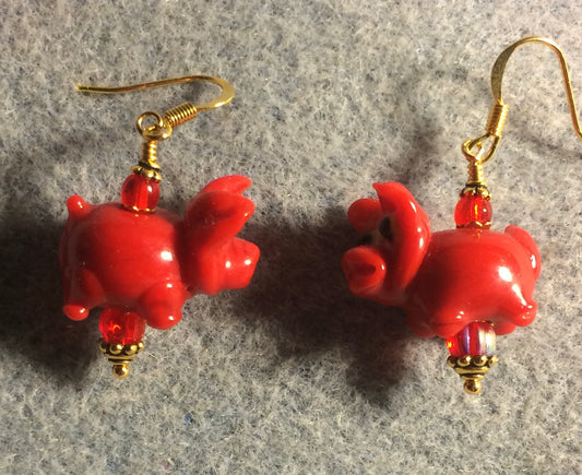 Red lamp work pig bead earrings adorned with red Czech glass beads.