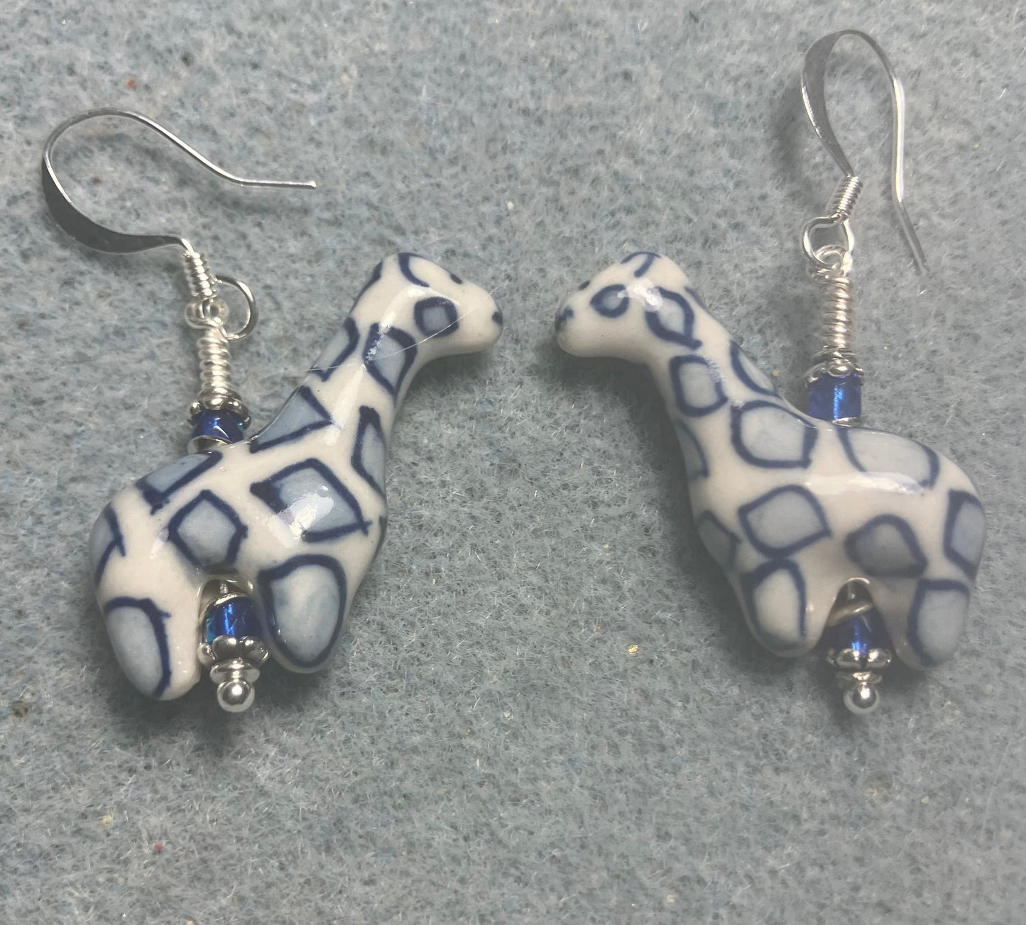 Dark blue and white ceramic spotted giraffe bead earrings adorned with small dark blue Czech glass beads.