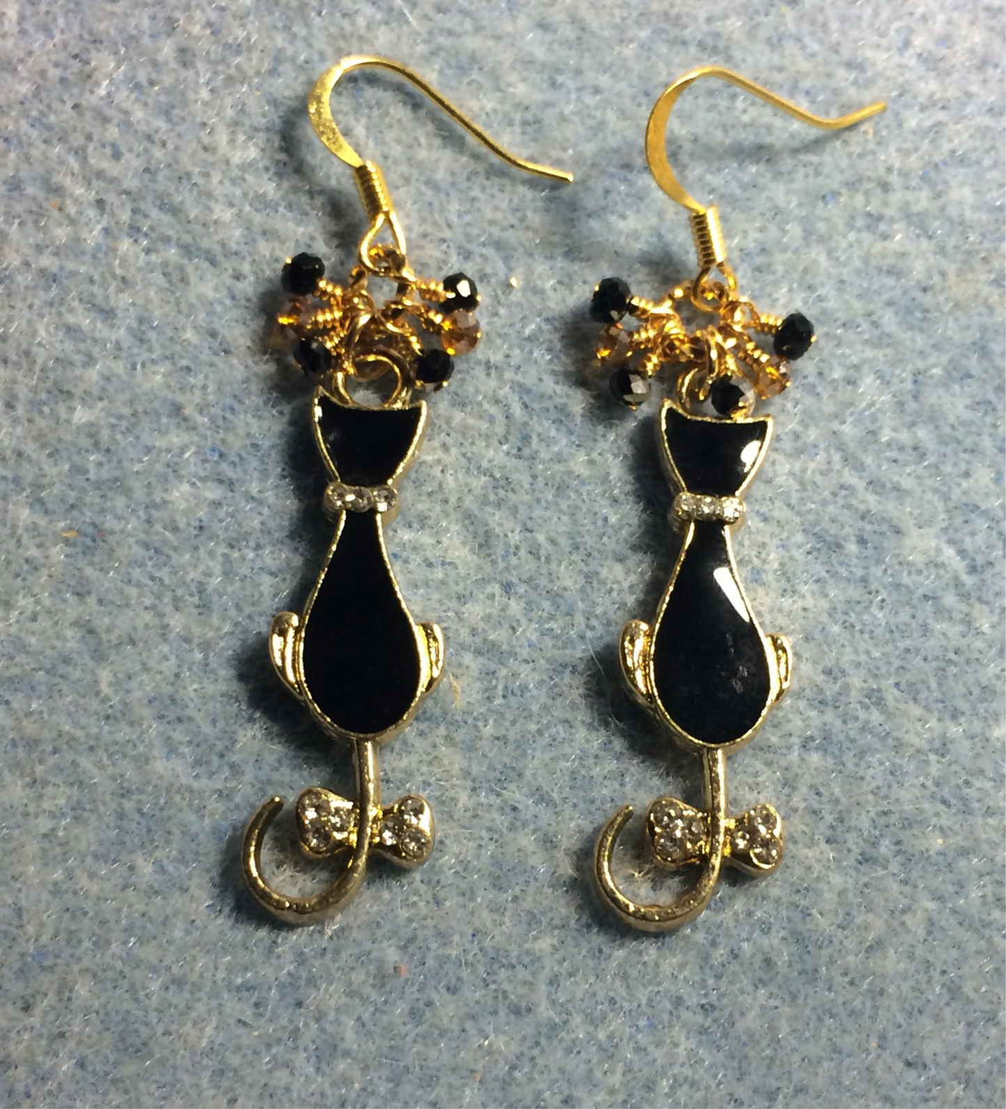 Black and gold enamel cat charm earrings adorned with tiny dangling black and gold Chinese crystal beads.