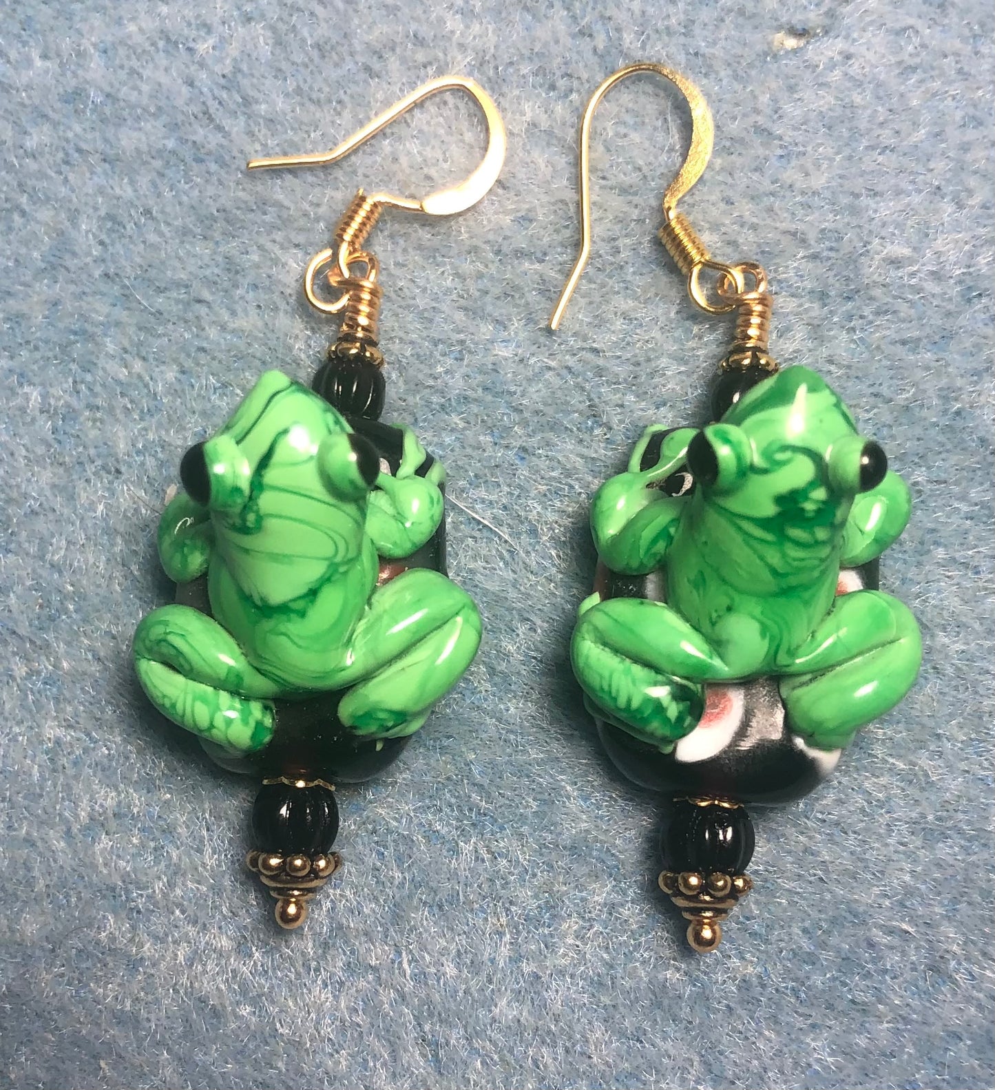 Bright green and black lamp work frog bead earrings adorned with black Czech glass beads.