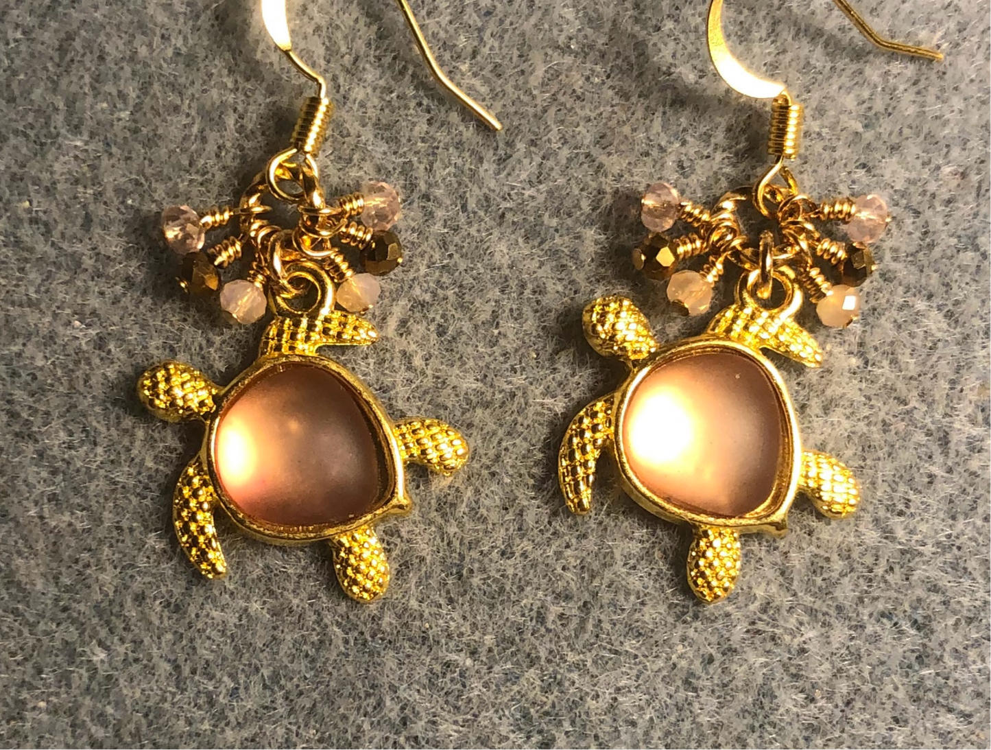 Gold and rose pink fiber optic sea turtle charm earrings adorned with tiny dangling peach, pink, and gold Chinese crystal beads.