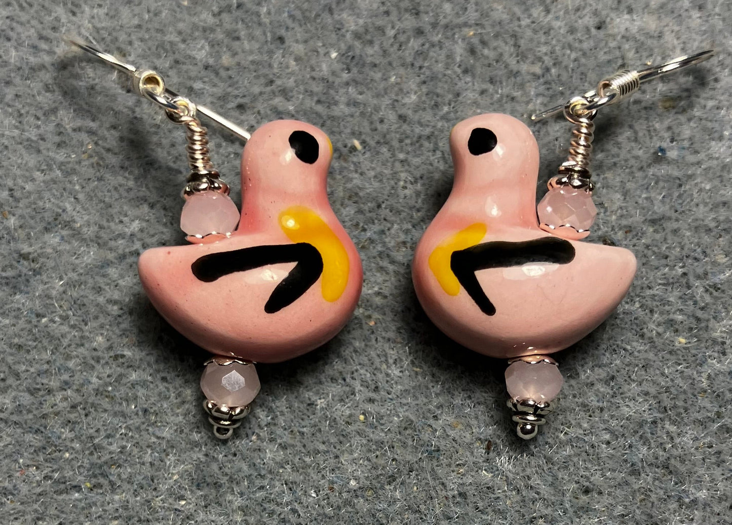 Pink, black, and yellow ceramic duck bead earrings adorned with pink Chinese crystal beads.