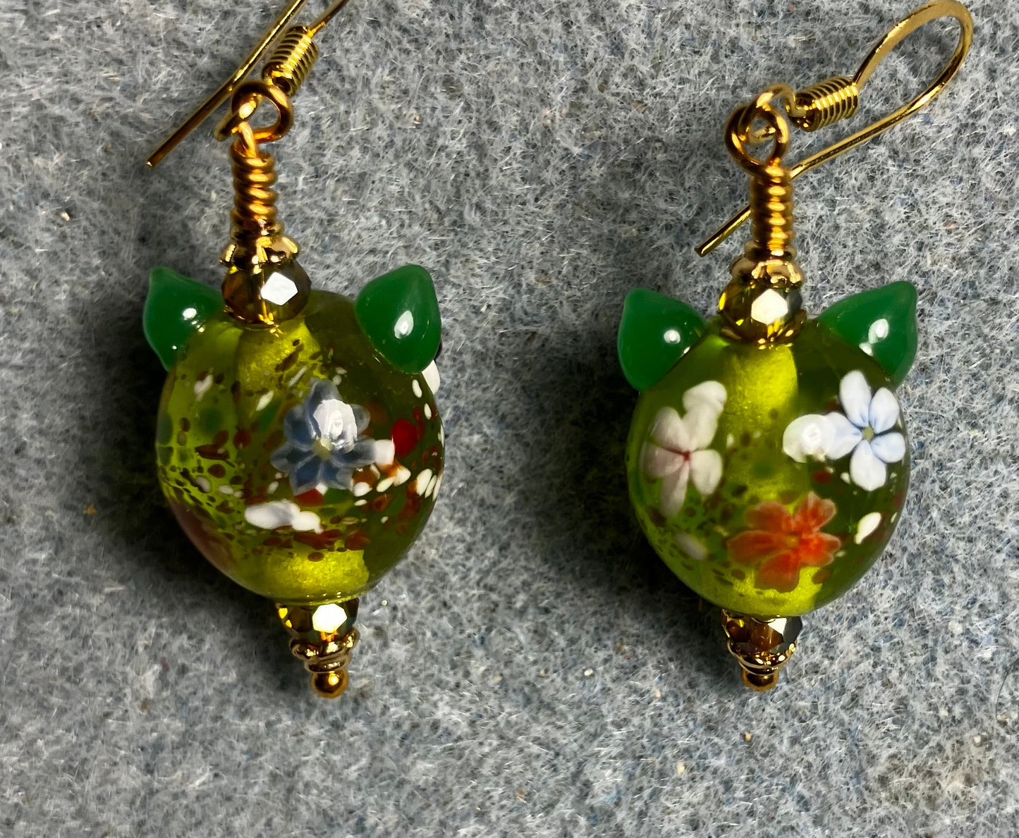 Olive green, orange, and red lamp work owl bead earrings adorned with olive green Chinese crystal beads.