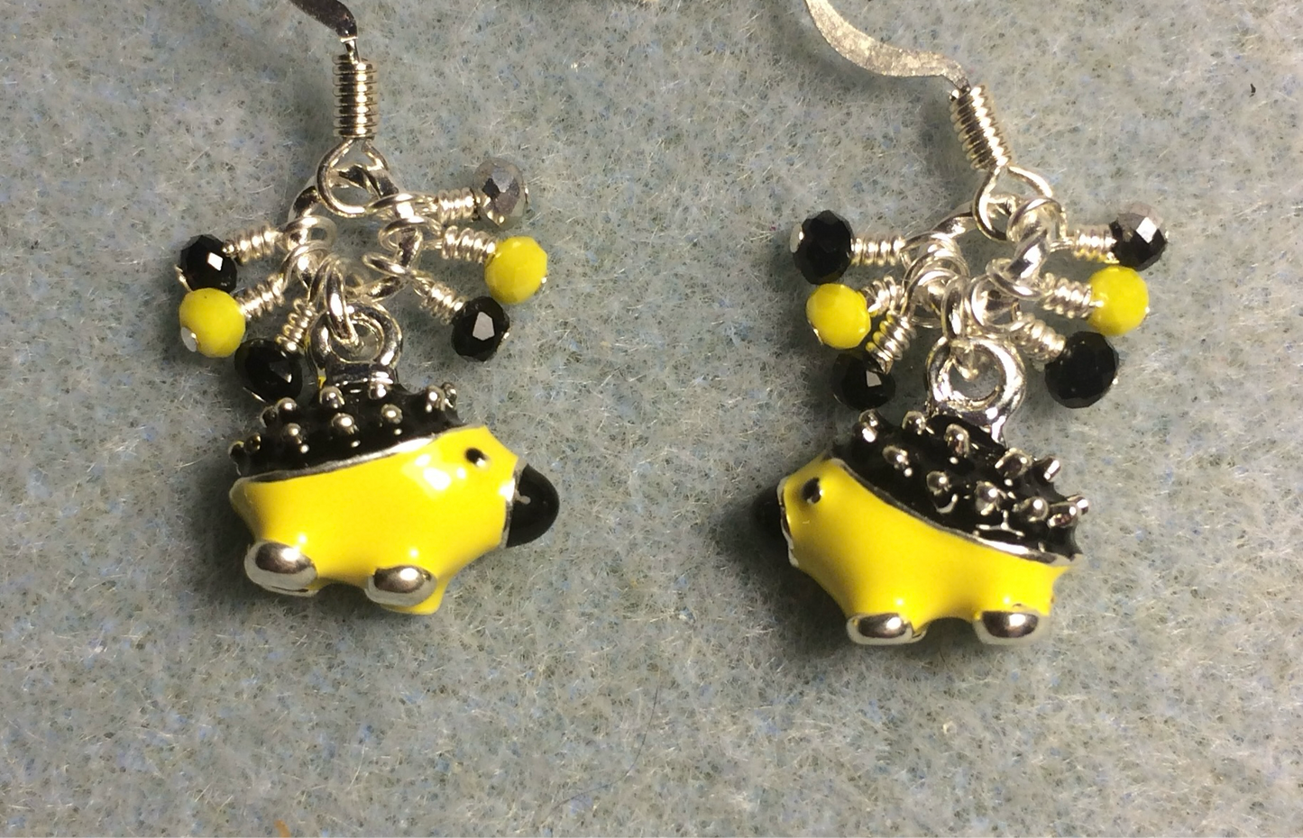 Yellow, black, and silver enamel porcupine charm earrings adorned with tiny dangling yellow and black Chinese crystal beads.