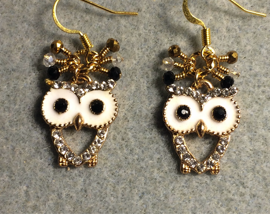 White, gold, and black enamel and rhinestone owl charm earrings adorned with tiny dangling clear, gold, and black Chinese crystal beads.