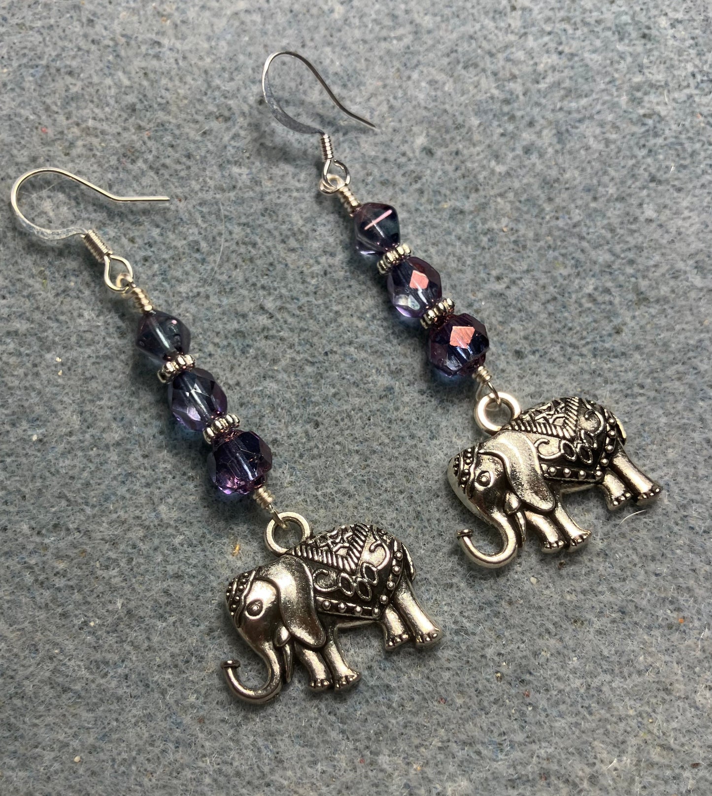 Ornate silver elephant charm earrings adorned with violet Czech glass beads.