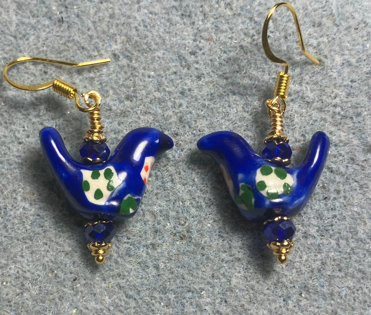 Small dark blue, white, and green ceramic bird bead earrings adorned with dark blue Chinese crystal beads.