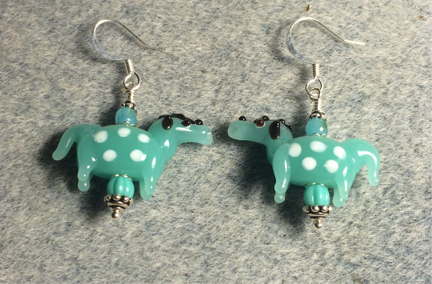 Milky turquoise and white lamp work spotted horse bead earrings adorned with turquoise Czech glass beads.