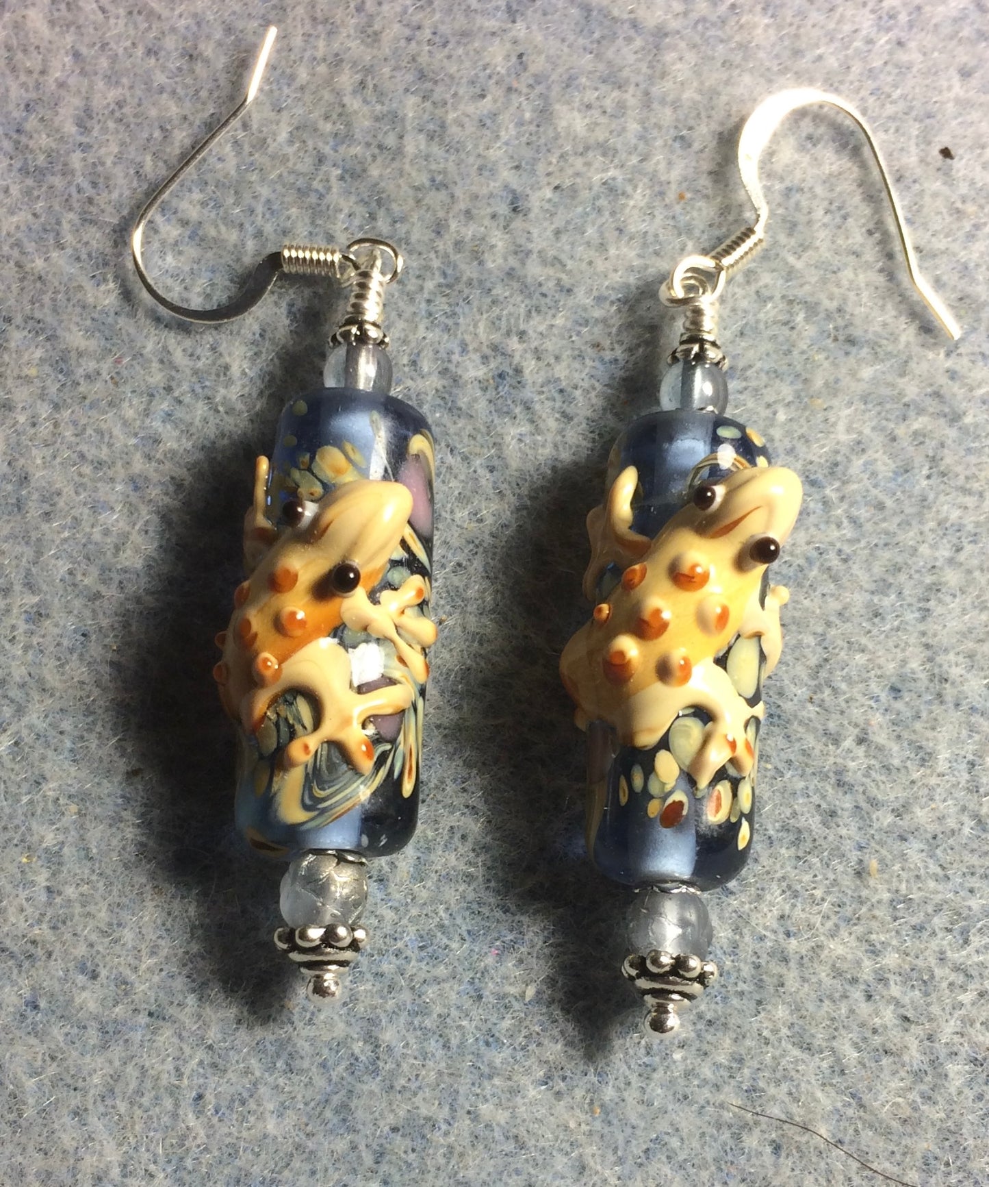 Light blue and tan lamp work lizard bead earrings adorned with light blue Czech glass beads.