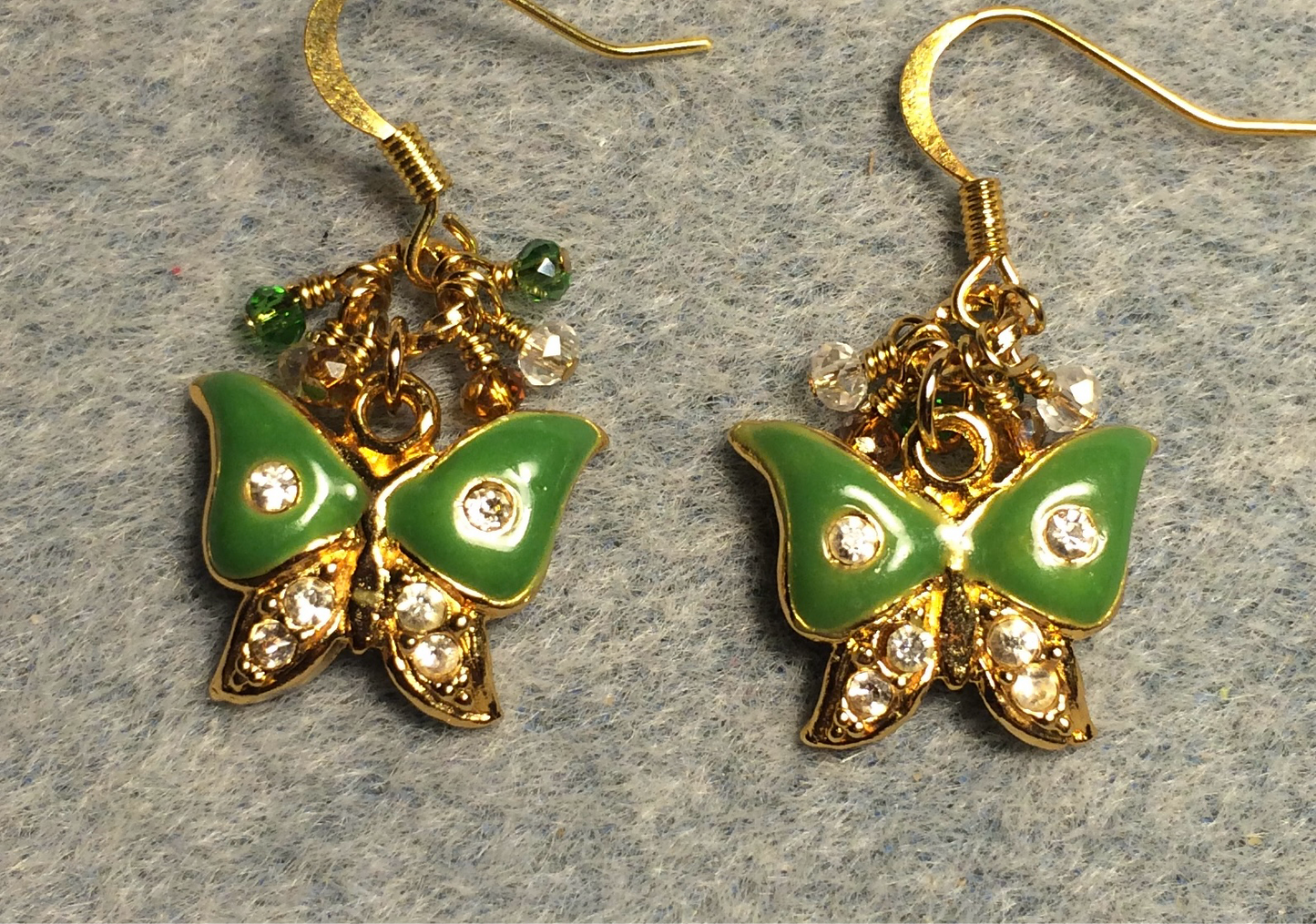 Vintage green and gold enamel and rhinestone butterfly charm earrings adorned with tiny dangling green, clear, and amber Chinese crystal beads.