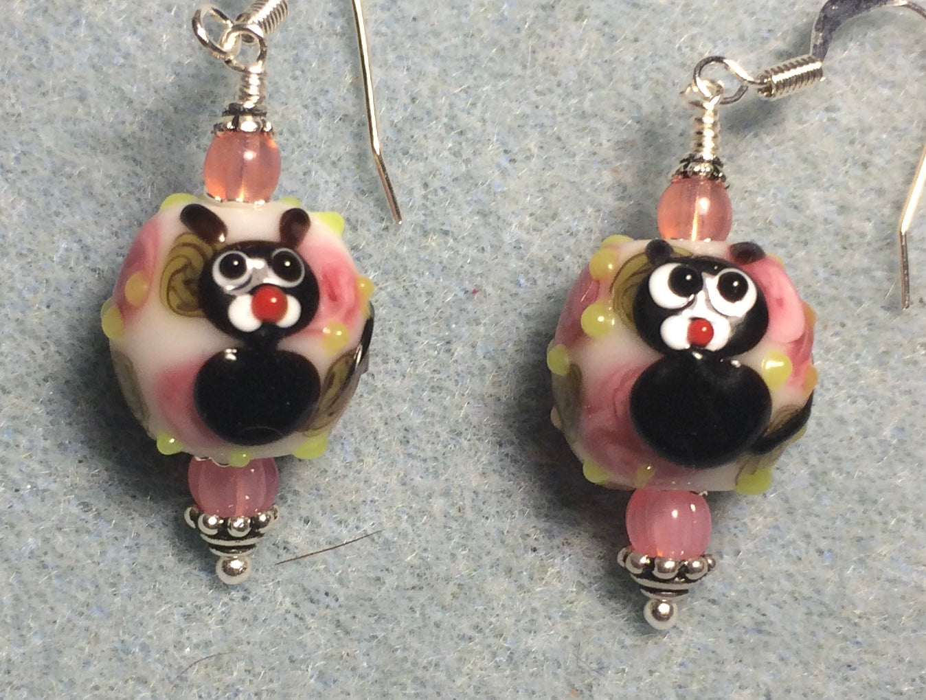 Pink, black, and white lamp work spherical cat bead earrings adorned with pink Czech glass beads.